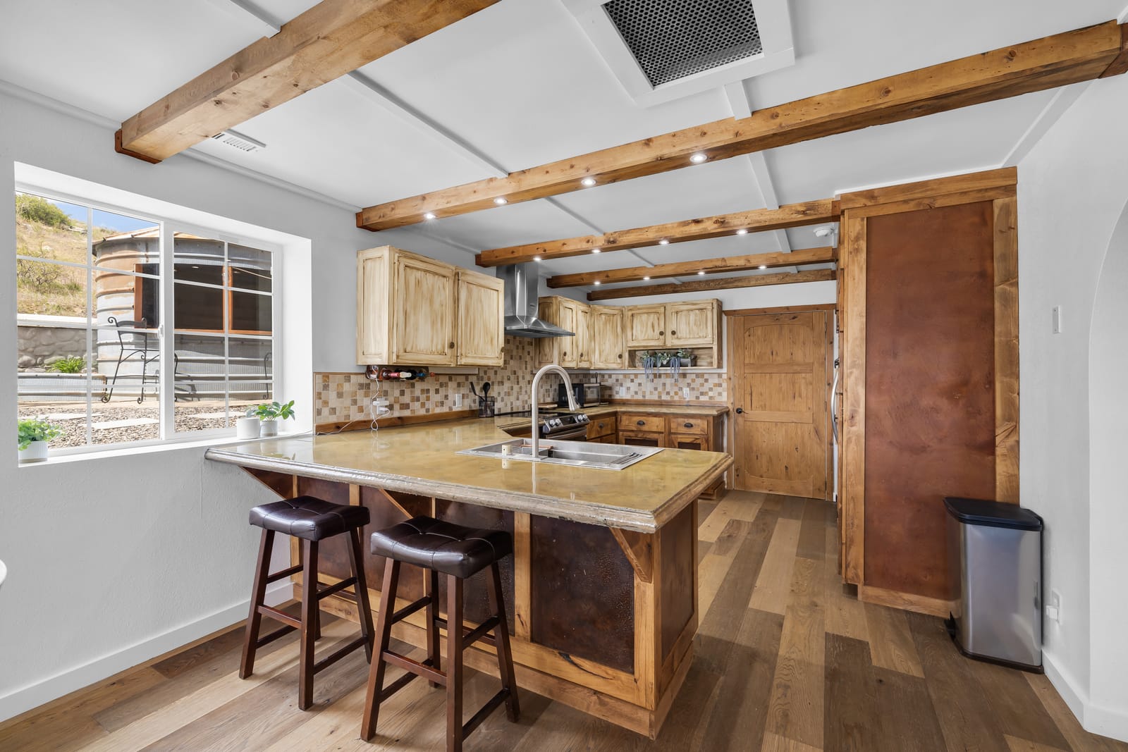 Full kitchen with a breakfast bar, wood cabinetry, and stainless appliances at the New Frontier Recovery Center property in Huntley, Montana