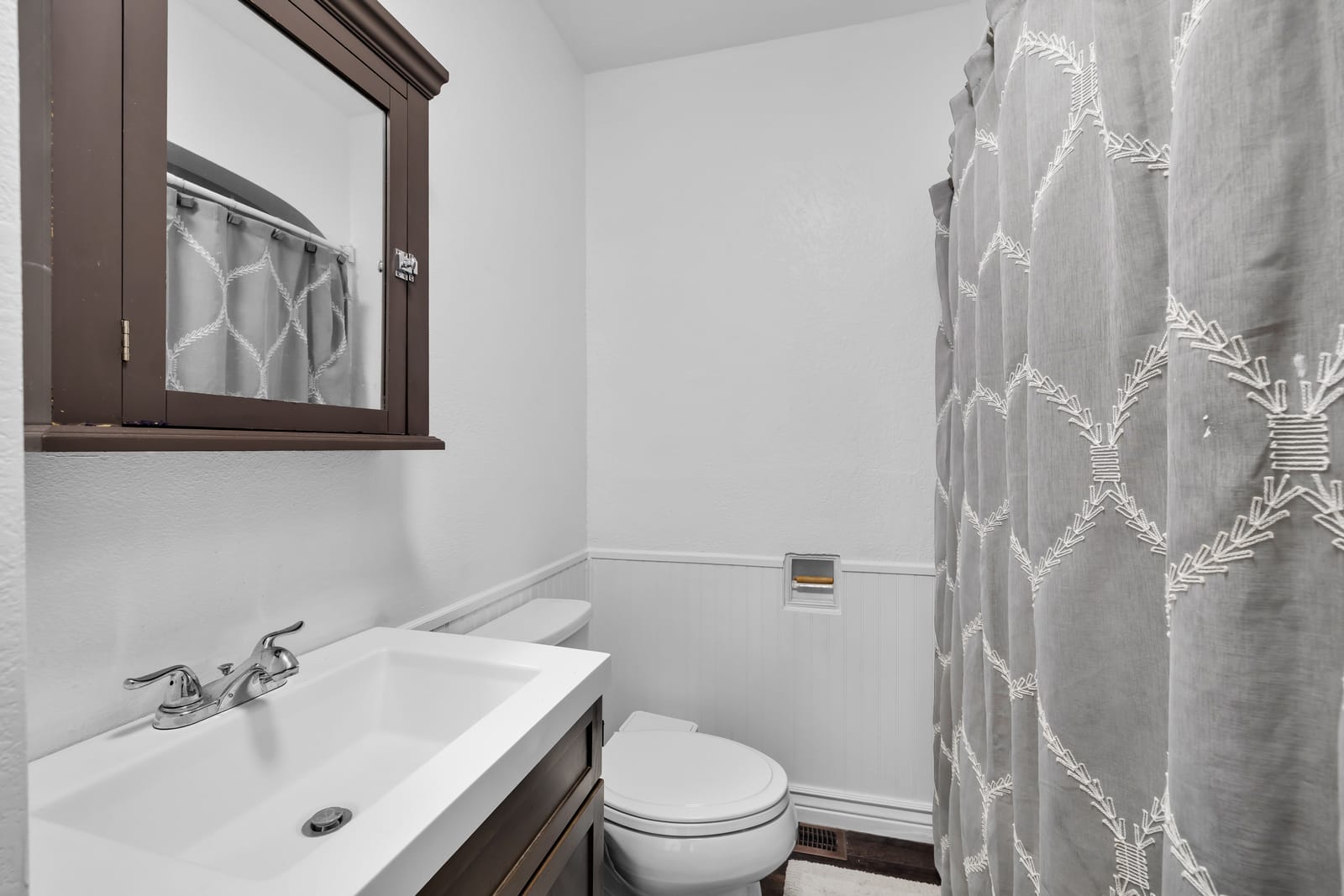 Clean private bathroom with a tiled walk-in shower and a vanity at the New Frontier Recovery Center property in Huntley, Montana